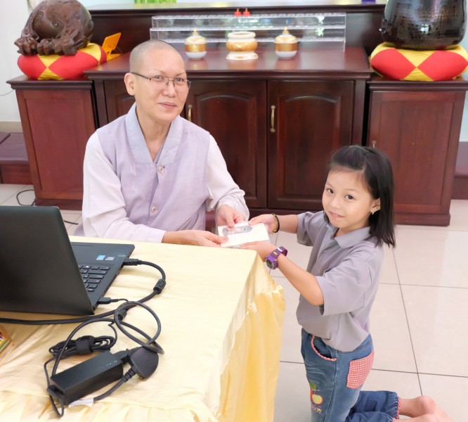 真信法师颁发福智十善法证明卡给霈霓小菩萨。