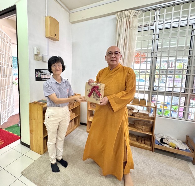 檀香寺副秘书奕燕将纪念品颁发给住持真升法师。