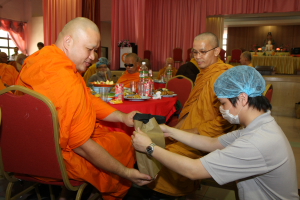 义工代表主办单位给法师献上日常用品及果仪