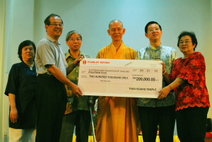 檀香佛教福利会副主席曾建忠(左2)移交模拟支票给泰国檀香基金会代表莎兰雅,由(左3起)泰国驻槟副领事仲查闰、唯悟法师和林冠英见证(光华照片)