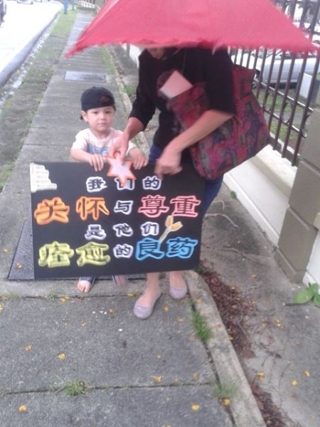 义工翠霞带她的孙子参与游行