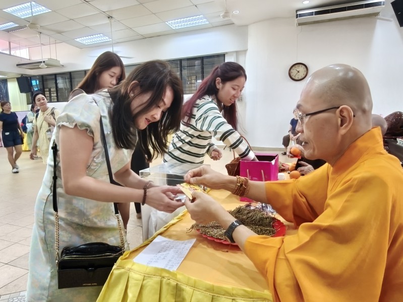 僧伽祝福区,信众拜年之际,法师们分发结缘品
