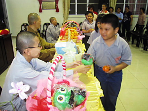 小菩萨们开心地向真醍法师领取可爱小娃娃恩物