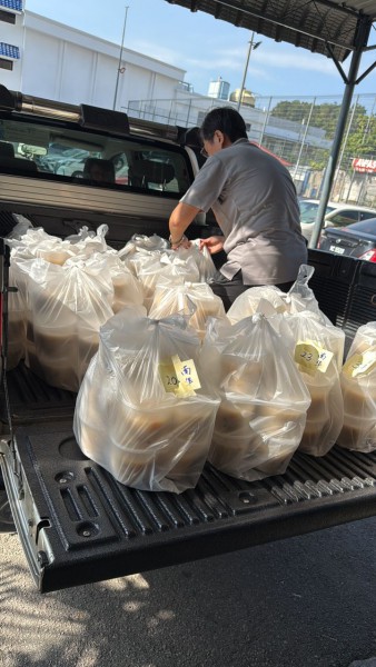 义工们把一袋一袋的腊八粥搬上车,准备送往目的地。