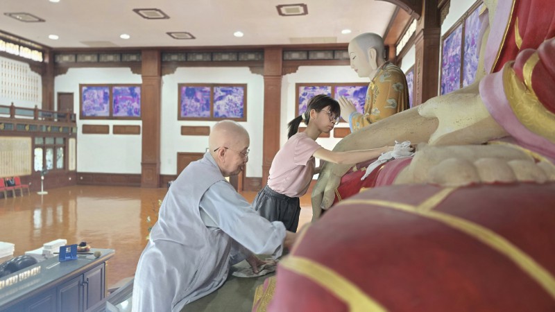 在第六楼层,法师和义工们认真地清理佛像。