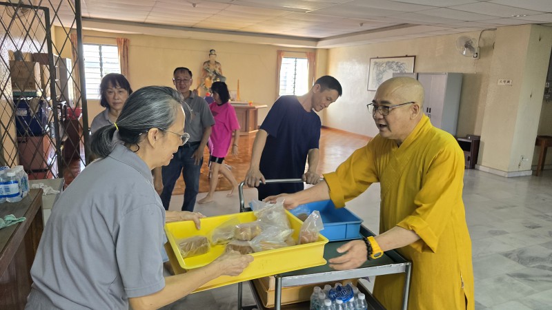 住持真升法师亲自到各楼层分发面包和矿泉水,温暖了大家的心。