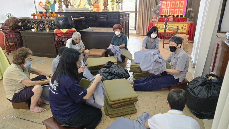 在底层,职员们和义工们认真地套垫子。