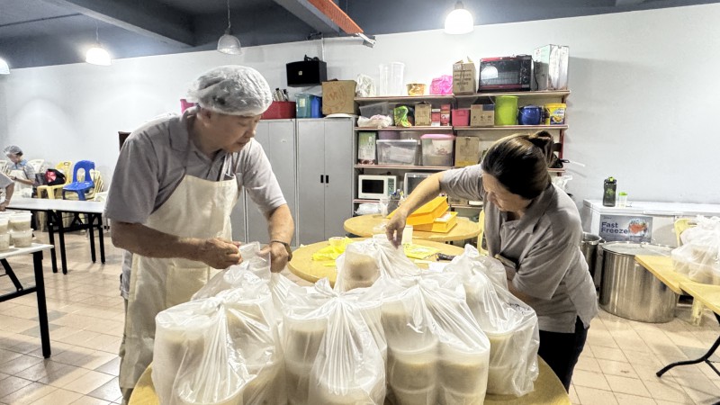 部分职员和义工则并肩合作,归类并点算腊八粥的数量